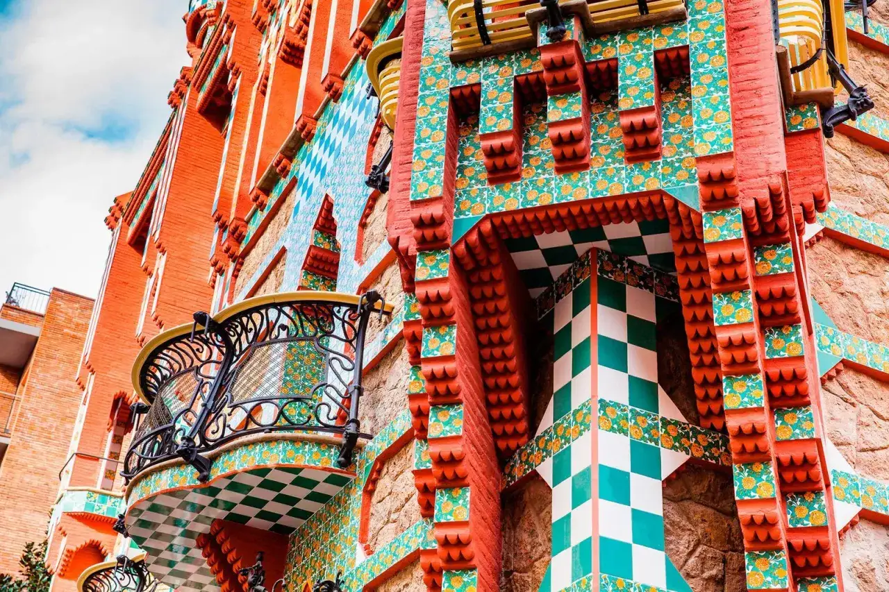 Detalle de **arte arquitectura** modernista con azulejos coloridos, balcones de hierro forjado y ladrillo visto.