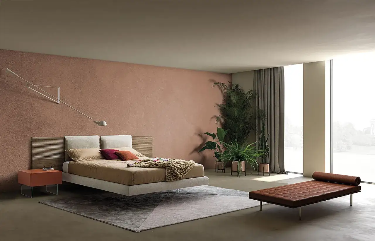 Modern bedroom with a floating bed, wooden cabecero con cojines ideas, plants, and a leather daybed.