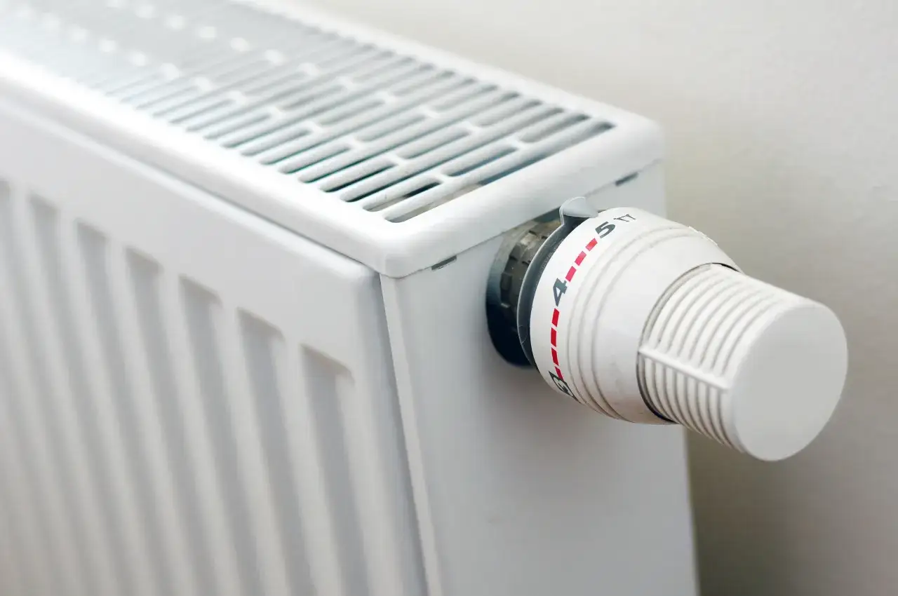 Biały grzejnik z termostatem ustawionym na 4. Zastanawiasz się, grzejnik elektryczny ile pobiera prądu?