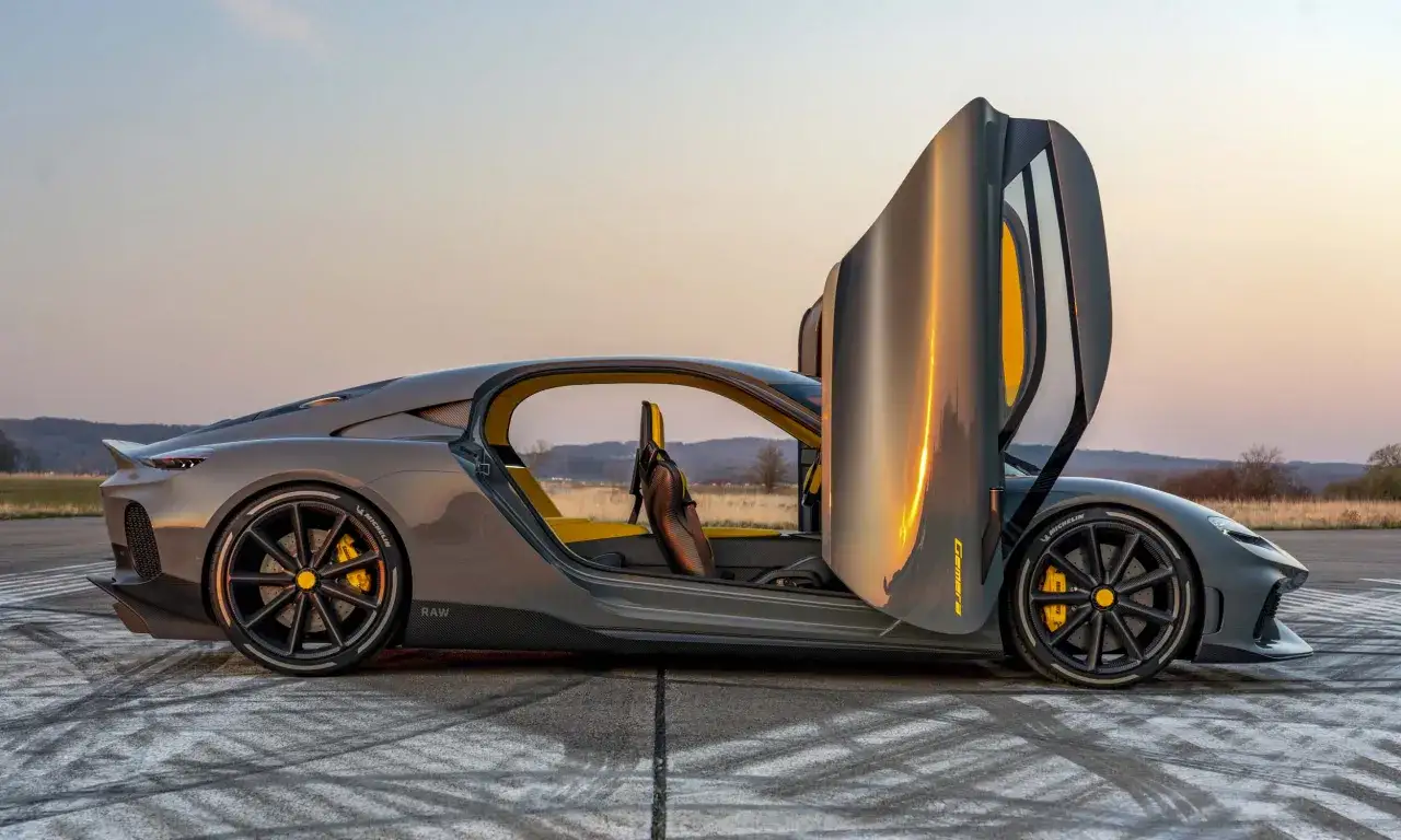 Szary Koenigsegg Gemera z otwartymi drzwiami, wnętrze z żółtymi akcentami. Cena tego cudu techniki jest astronomiczna.