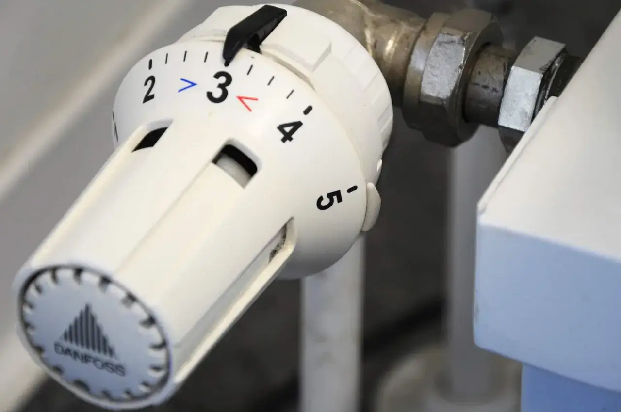 Detalle de la **instalación de válvulas termostáticas para radiadores**. El dial muestra la temperatura, con el número 3 en el centro.