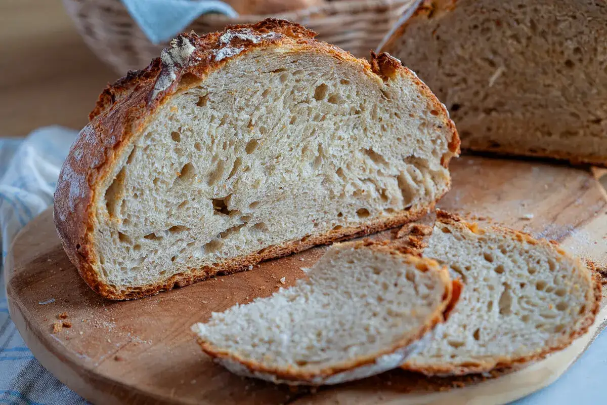 Frisch gebackenes Buttermilch Brot mit knuspriger Kruste und luftiger Krume, auf einem Holzbrett angeschnitten.