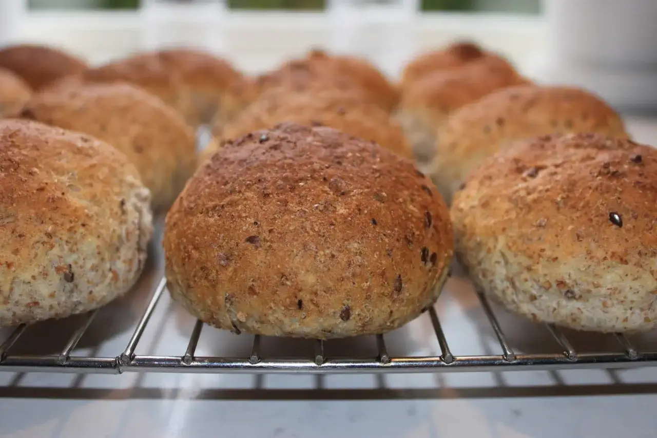 Nybakade grahamsbullar med fr&ouml;n p&aring; ett galler. Perfekt f&ouml;r ett gott grahamsbullar recept.