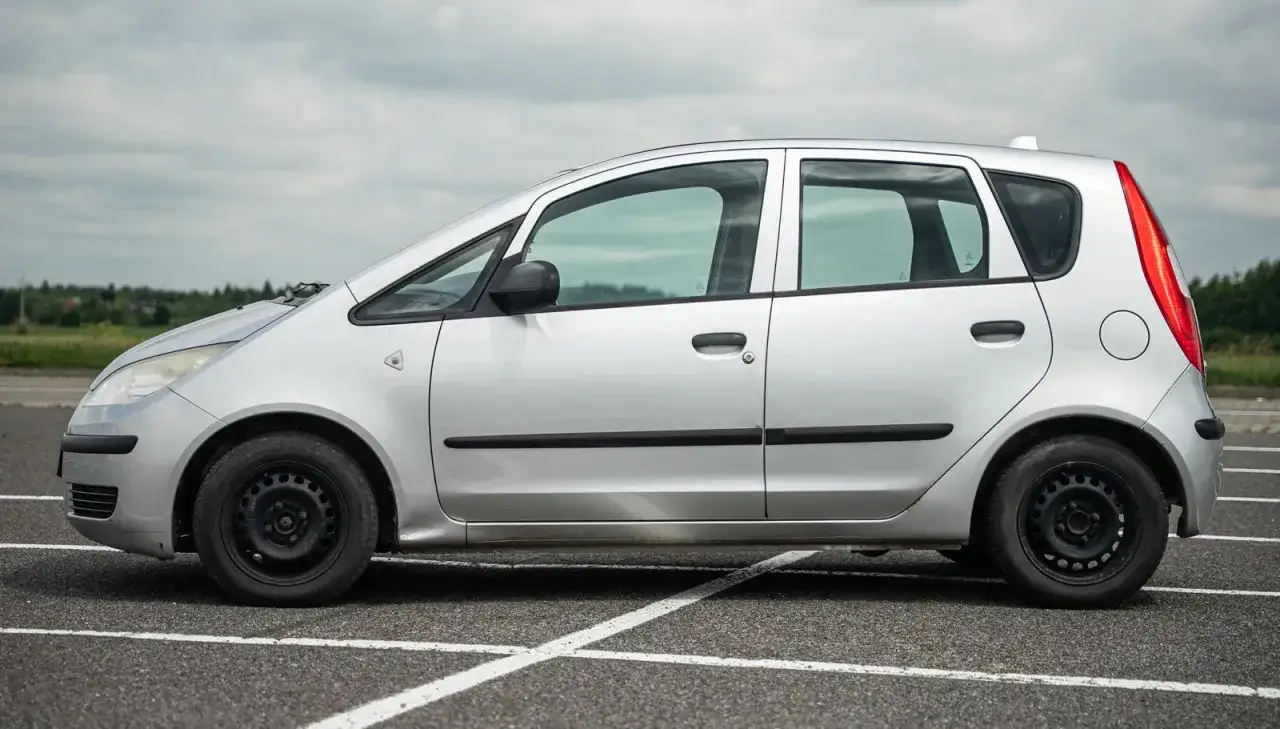 Srebrny Mitsubishi Colt 2006 stoi na parkingu.