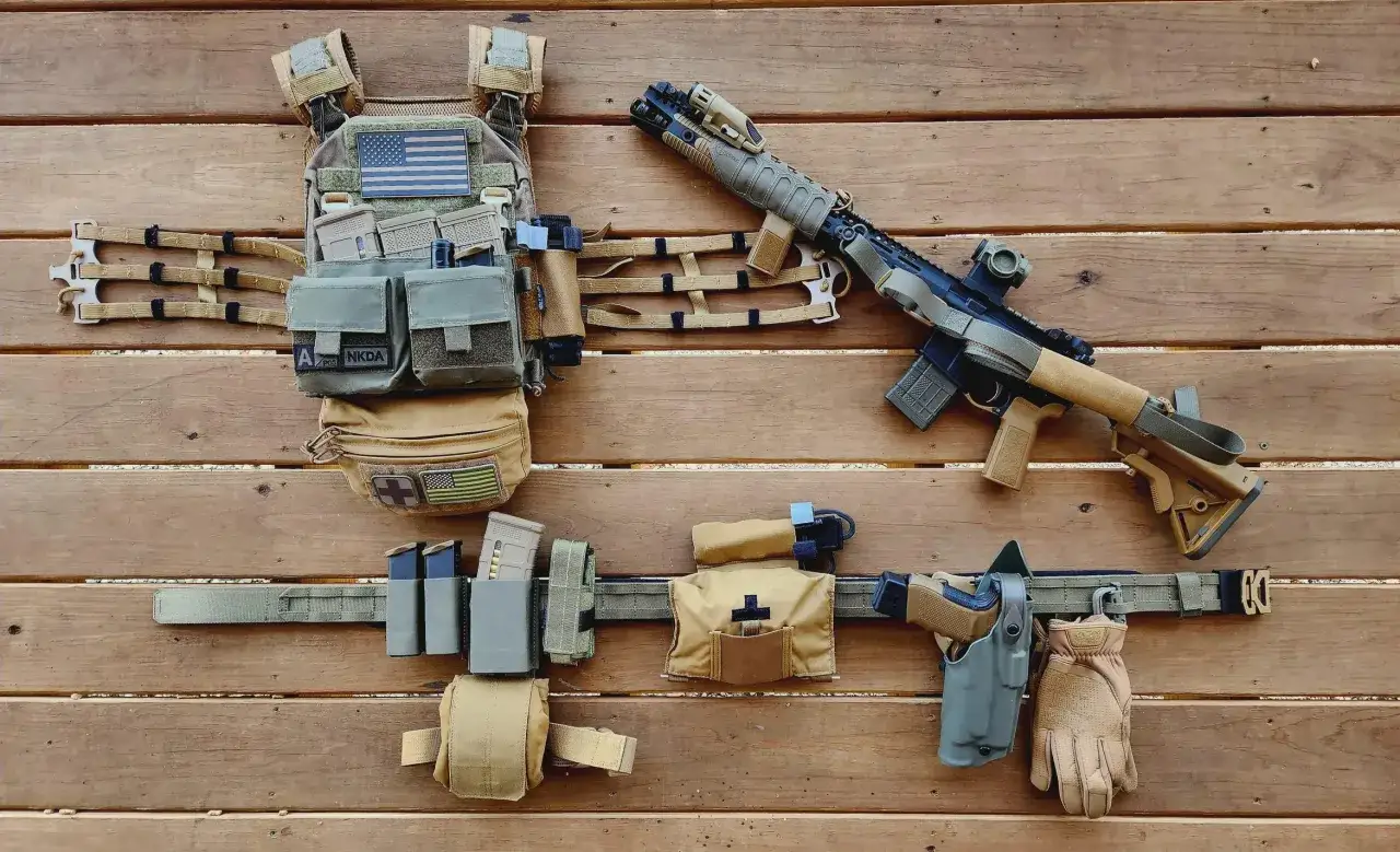 Kamizelka taktyczna i pas z wyposażeniem w kolorze coyote: karabin, pistolet, magazynki, apteczka i rękawice.