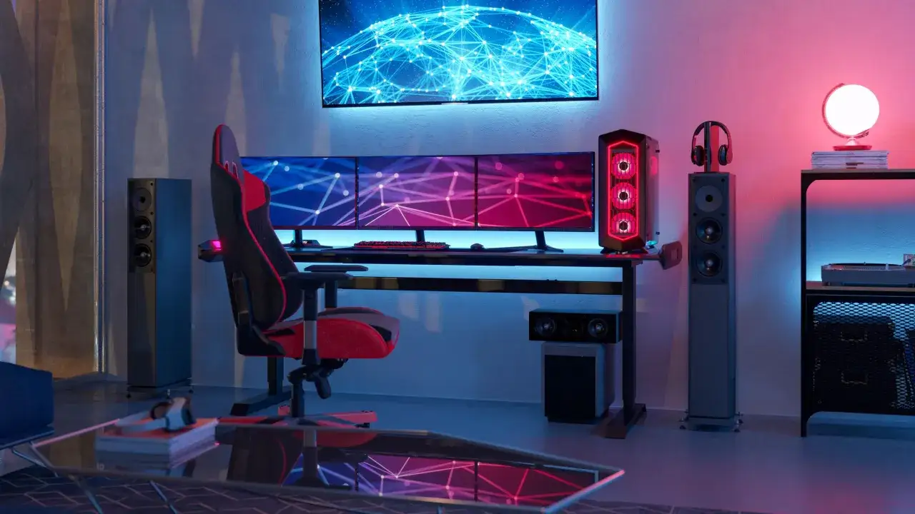 Nowoczesne stanowisko gamingowe z trzema monitorami, RGB, słuchawkami i głośnikami. Dowiedz się, jak podłączyć dwa monitory do PC, by cieszyć się pełnią wrażeń.