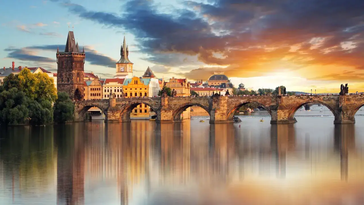 Karlsbr&uuml;cke in Prag bei Sonnenuntergang, ein Wahrzeichen der Stadt. Die Spiegelung der Br&uuml;cke und der Geb&auml;ude im Wasser ist ein Highlight.