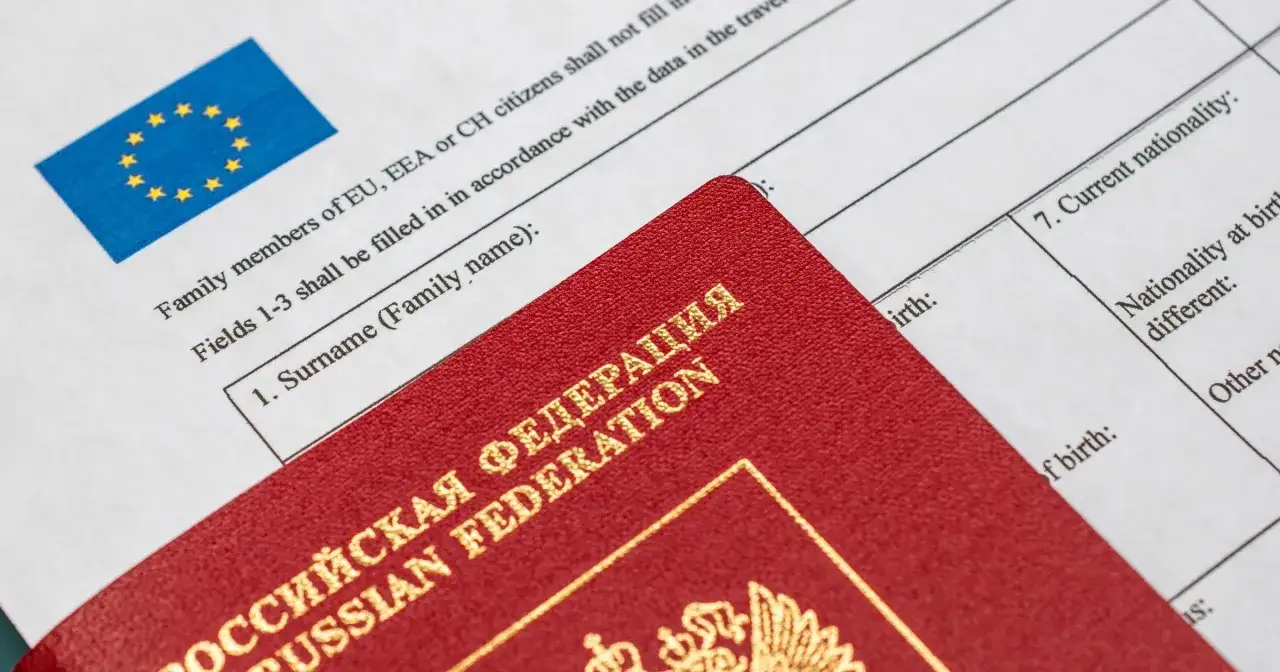 Czerwony paszport Federacji Rosyjskiej na tle formularza wizowego z flagą UE. Dokumenty potrzebne do uzyskania wizy.