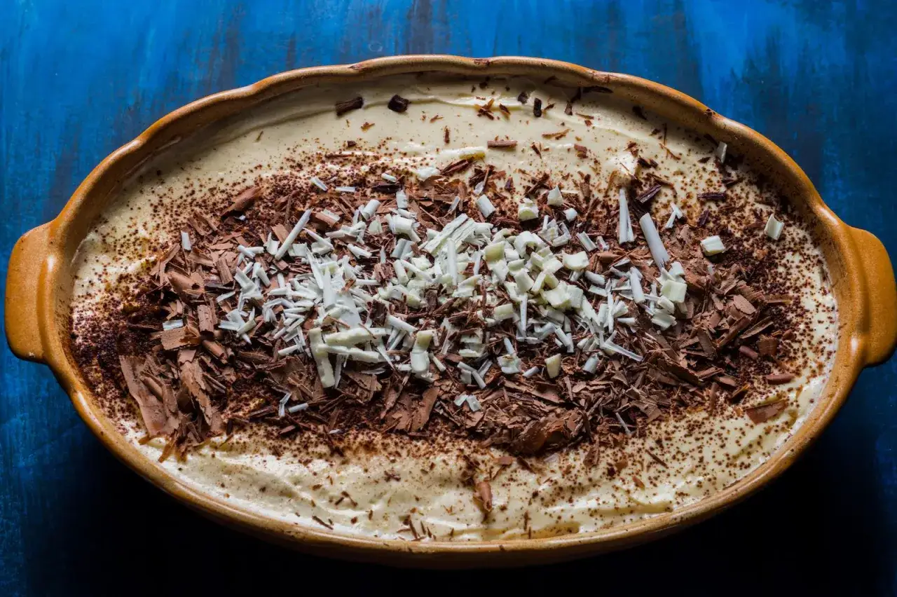 Tiramisù, un classico dolce da provare a Padova. Cremoso, con abbondante cacao e scaglie di cioccolato fondente e bianco.