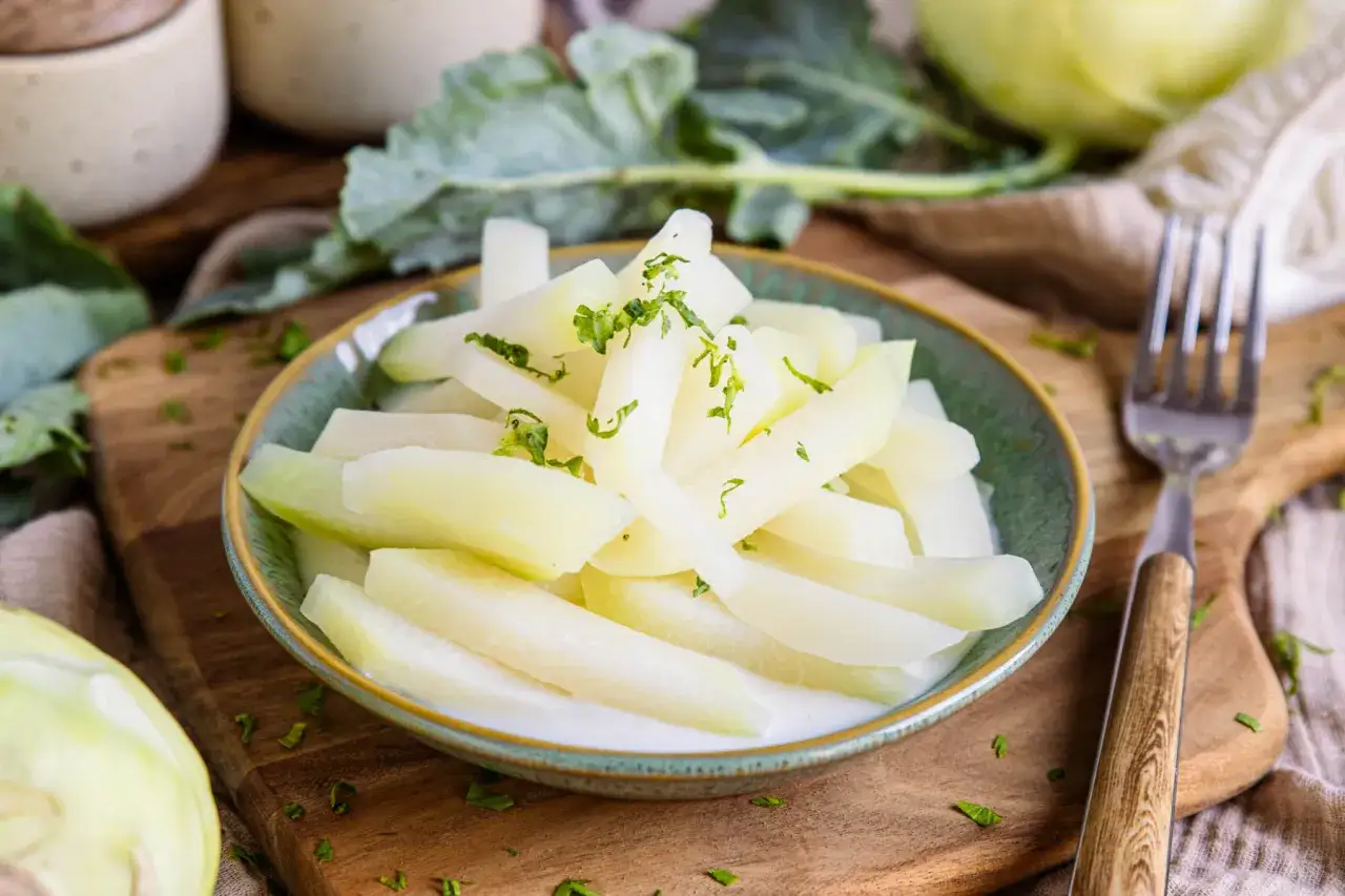 Gedünsteter Kohlrabi, in mundgerechte Stücke geschnitten und mit frischer Petersilie garniert, bereit zum Genießen.
