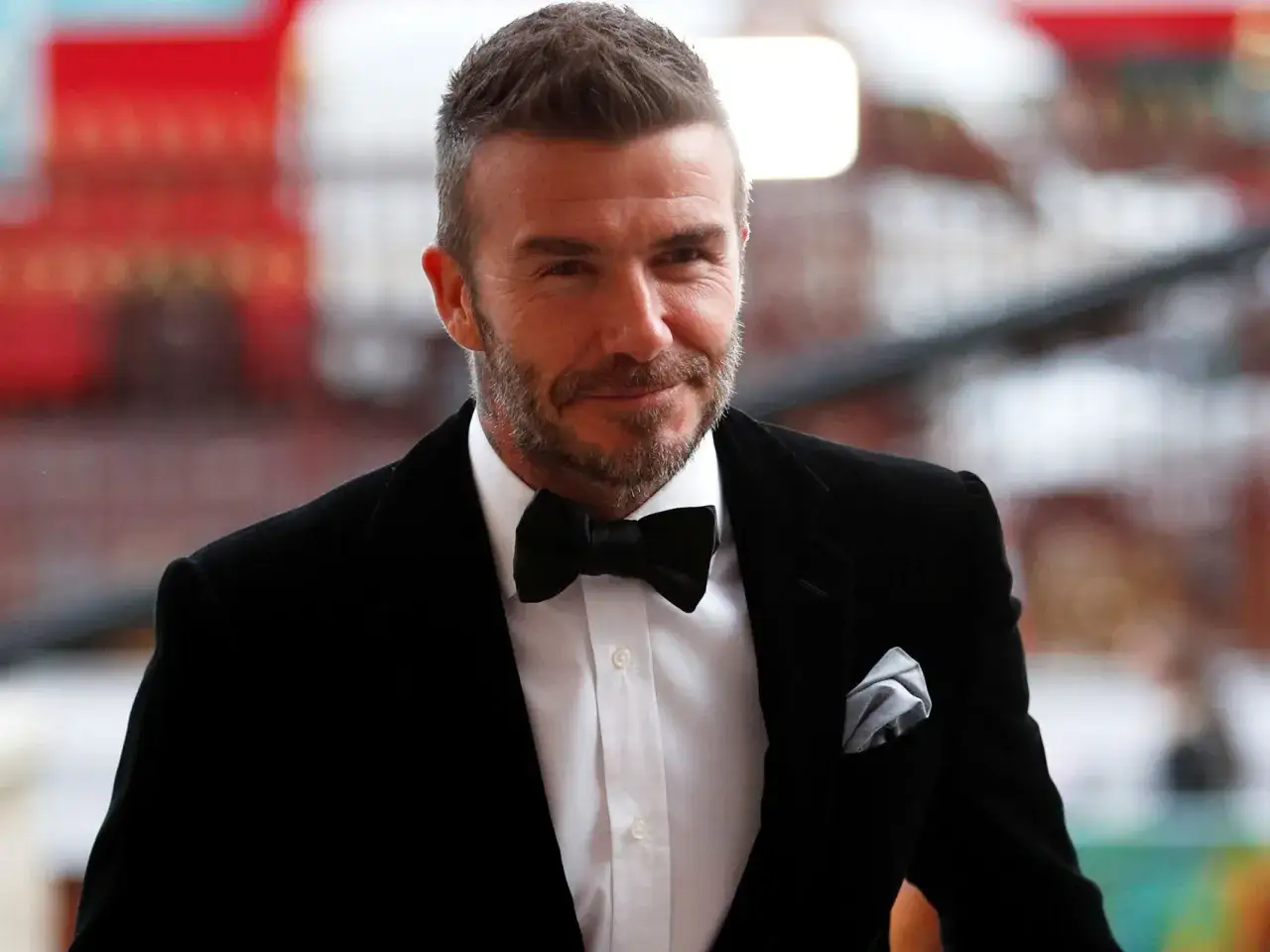 David Beckham in a tux, showing how to fold a pocket square for a formal look.