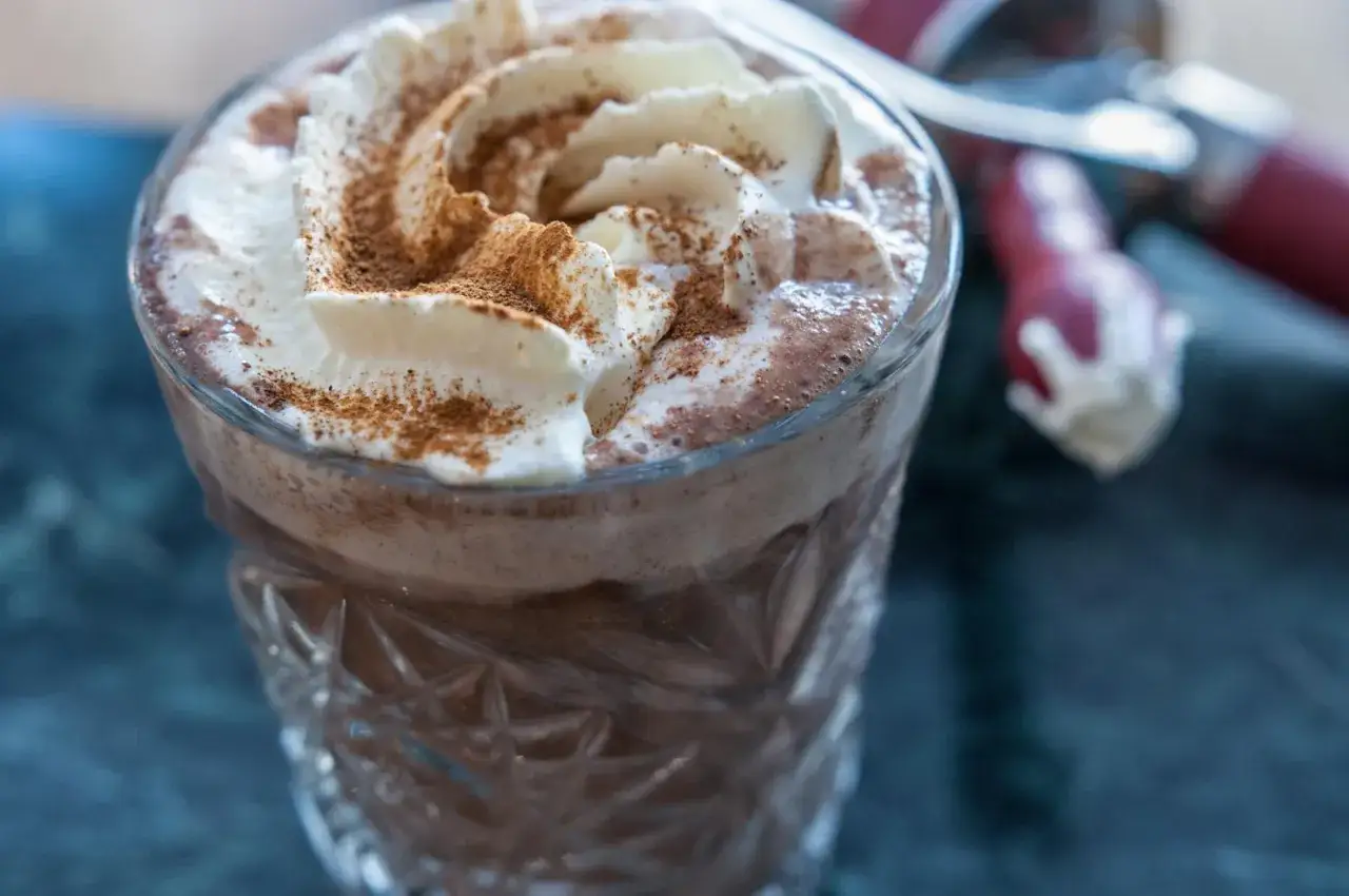 En härlig varm choklad med fluffigt grädde och kanel. Perfekt för en mysig stund.