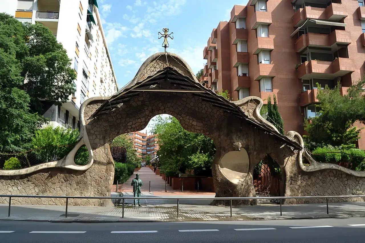 Portail organique rappelant l'architecture de Gaudi &agrave; Barcelone, avec une statue d'homme devant.