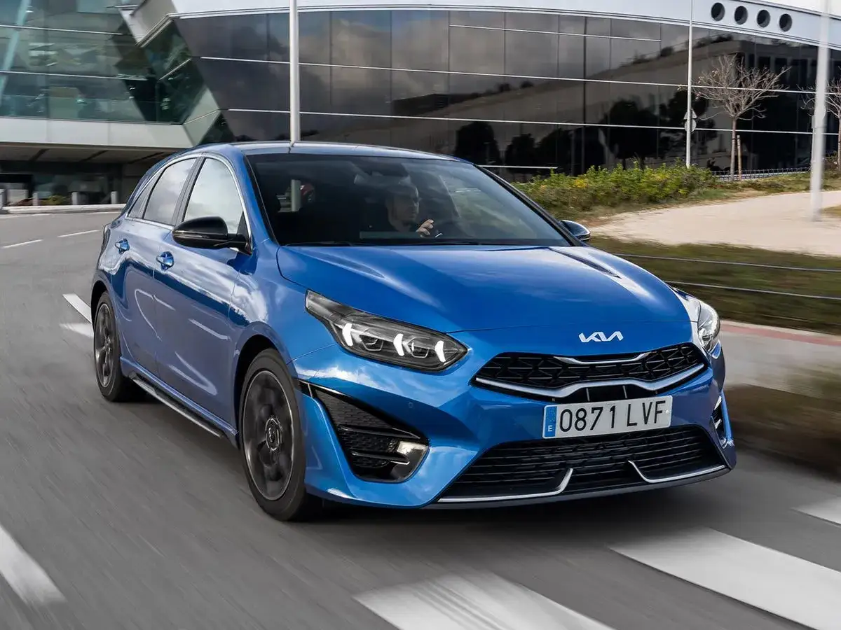 Un Kia Ceed azul en movimiento, listo para una prueba de conducción. Su diseño deportivo y moderno se destaca en la carretera.