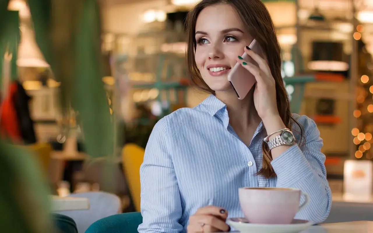 kobieta rozmawia na telefonie z uśmiechem
