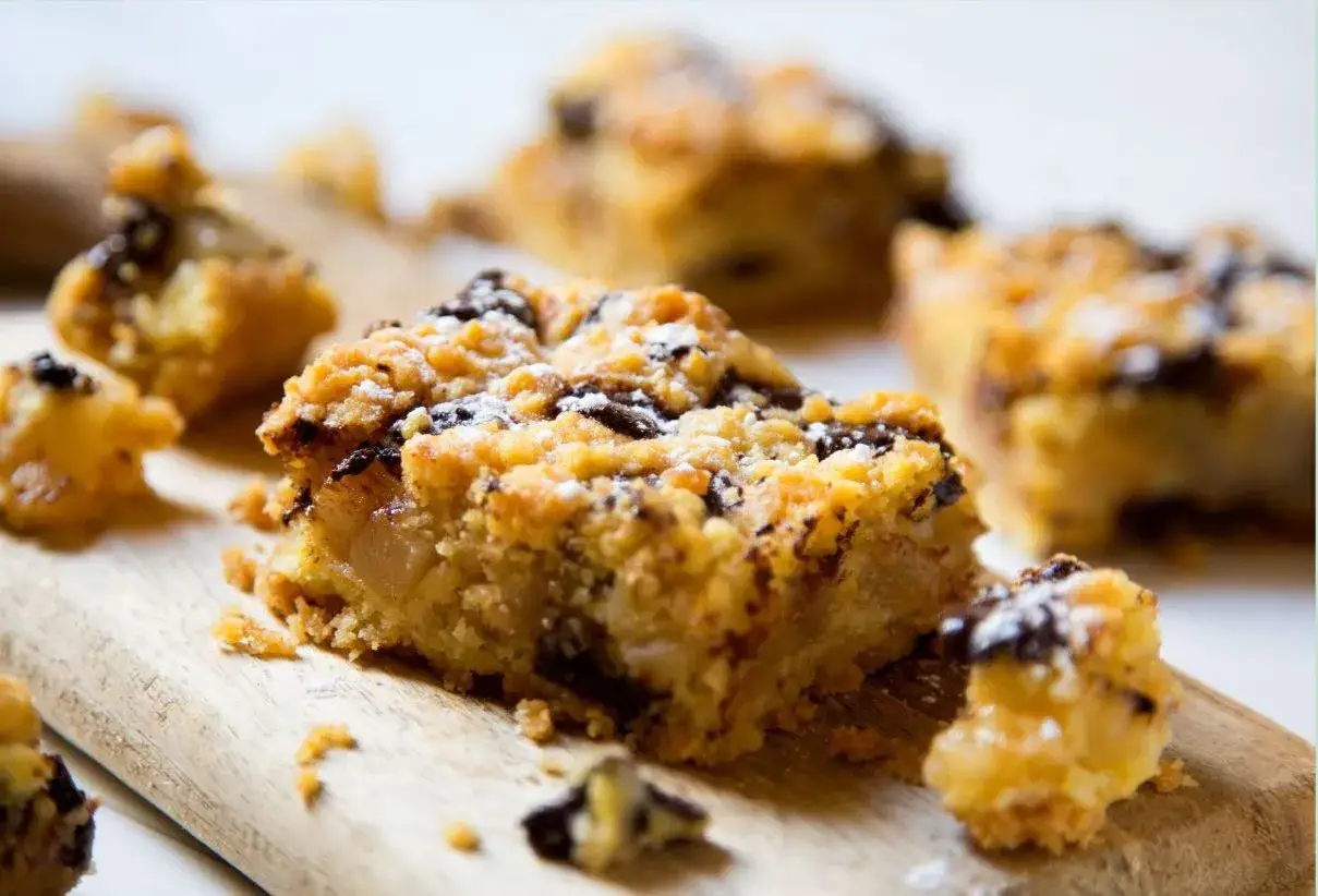 Délicieux carrés de pomme et chocolat avec une pâte à crumble croustillante, saupoudrés de sucre glace.