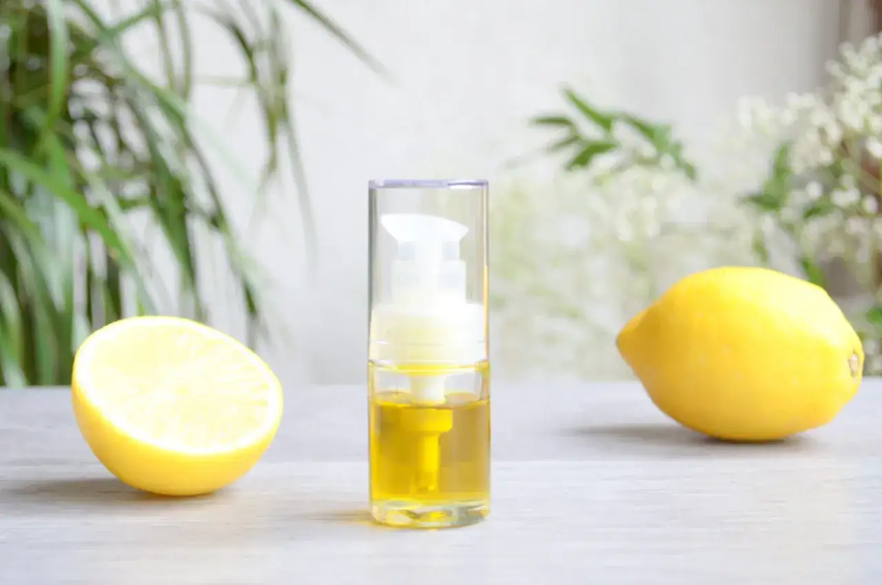 Un flacon d'huile et des citrons, un rem&egrave;de de grand-m&egrave;re pour un ongle ab&icirc;m&eacute;.