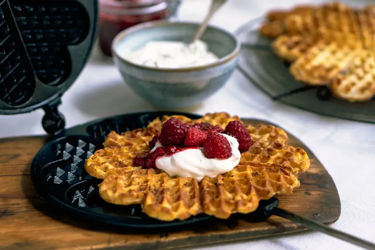 Nygräddade våfflor med grädde och hallon, ett perfekt recept för fika.