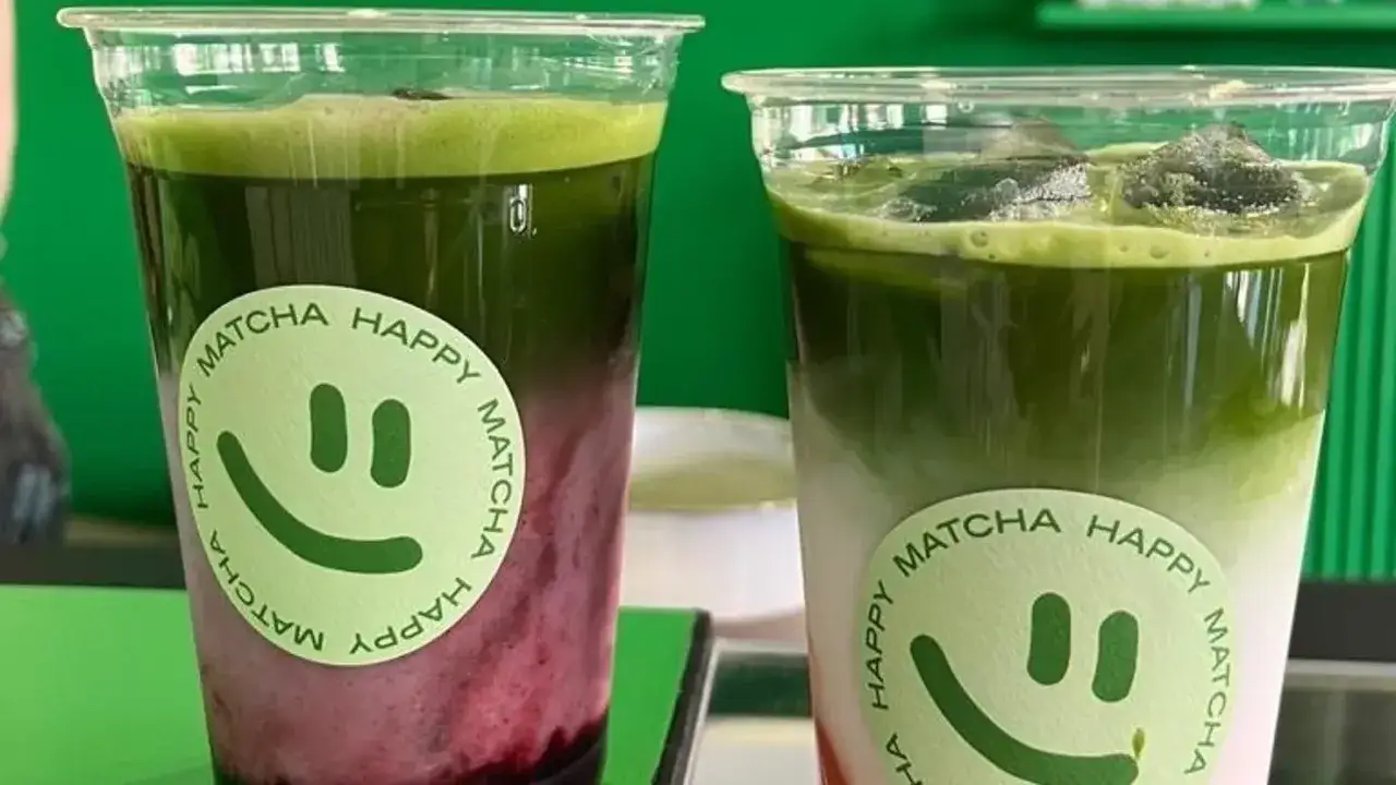 Zwei erfrischende Matcha-Getr&auml;nke mit l&auml;chelnden Aufklebern. Ein Genuss im Matcha-Caf&eacute;.