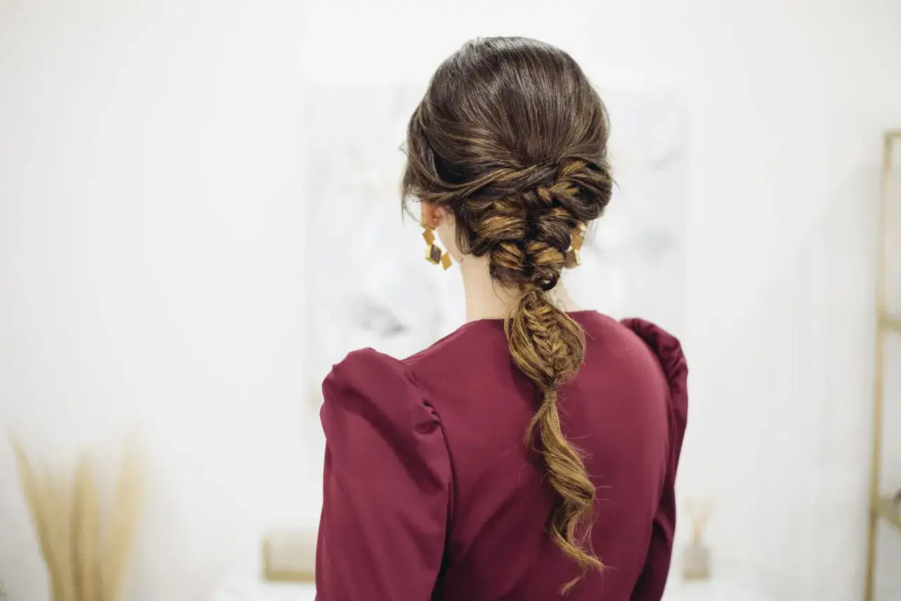Elegante trenza de boda invitada, con un estilo recogido y una cola de pez suelta.