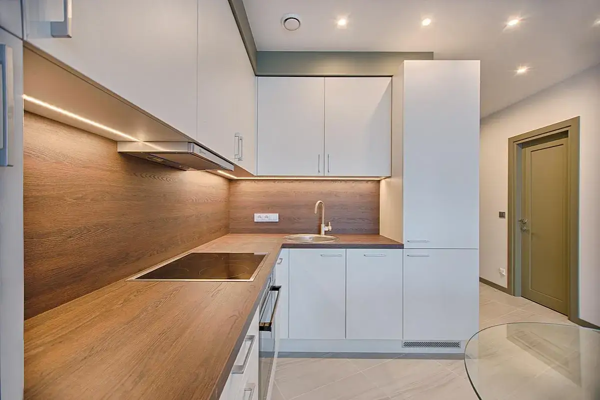 Cucina moderna con illuminazione a LED sotto i pensili, che crea un'atmosfera calda. Quanti lumen in cucina? Abbastanza per illuminare ogni angolo.