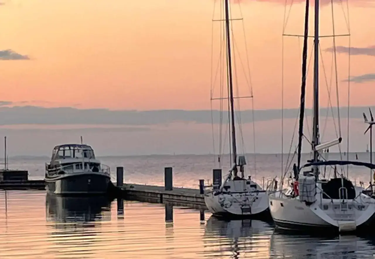 Segelboote im Hafen bei Sonnenuntergang. Ein friedlicher Moment des Segelns in Deutschland.