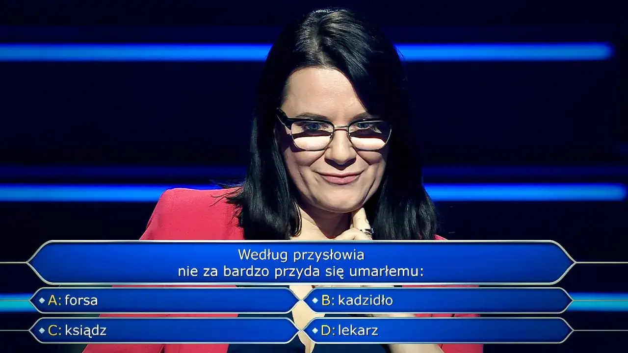 Kobieta w okularach na tle niebieskich pasów, zastanawia się nad pytaniem z teleturnieju