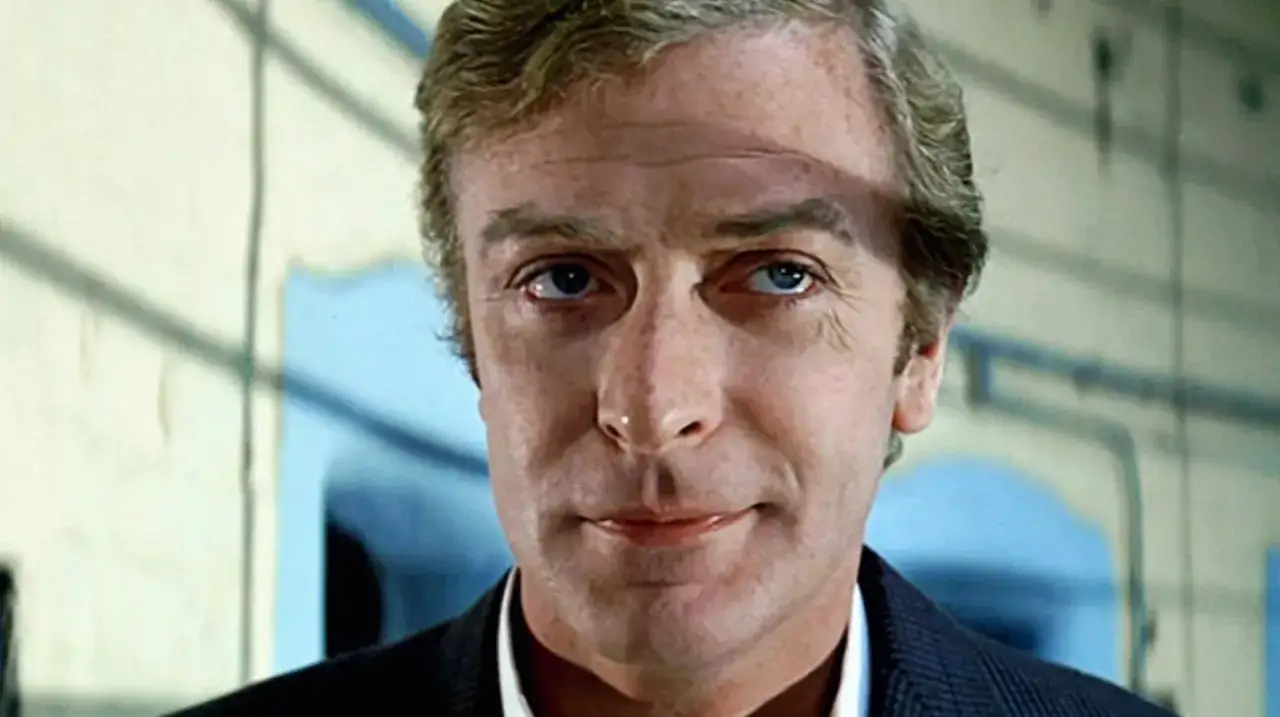 Michael Caine, en ikonisk skådespelare, i en närbild. Hans karaktäristiska blick och ansiktsdrag är framträdande, vilket påminner om hans många minnesvärda filmer med Michael Caine.