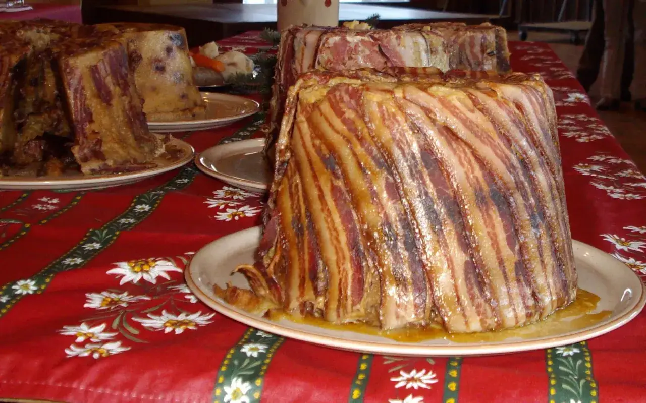 Un far&ccedil;on savoyard traditionnel, un plat g&eacute;n&eacute;reux et gourmand, est pr&eacute;sent&eacute; sur une nappe rouge orn&eacute;e de fleurs d'edelweiss.