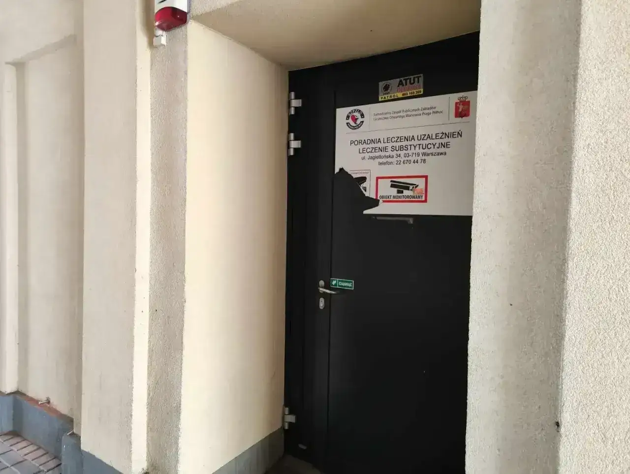 Drzwi poradni leczenia uzależnień, gdzie oferowany jest metadon. Obiekt monitorowany.