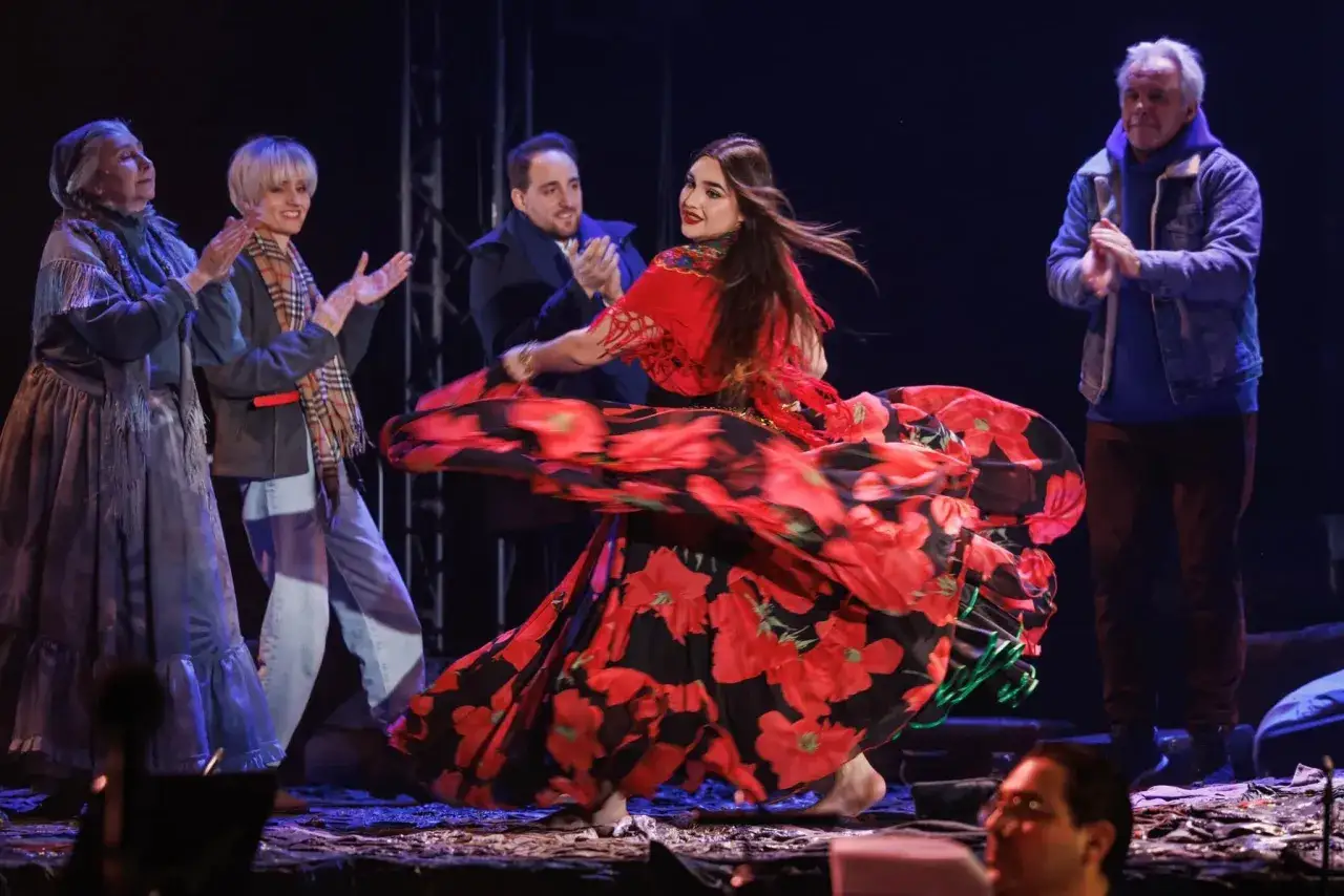 Tancerka w sukni w czerwone maki wiruje na scenie, a wokół niej ludzie klaszczą. To scena z przedstawienia, gdzie rozbrzmiewają cygańskie piosenki o miłości.