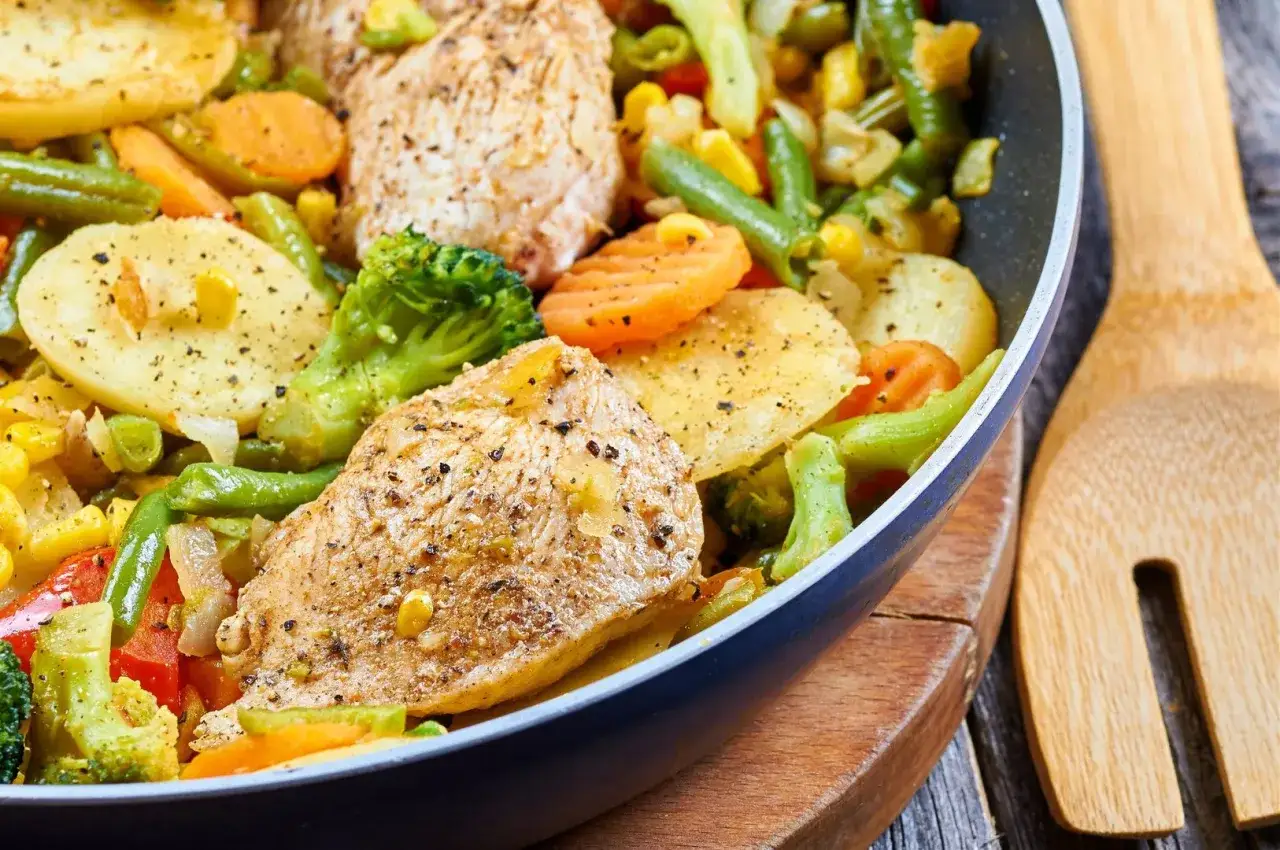 Sauté z kurczakiem i warzywami na patelni. Danie wygląda apetycznie, warzywa są świeże i kolorowe.