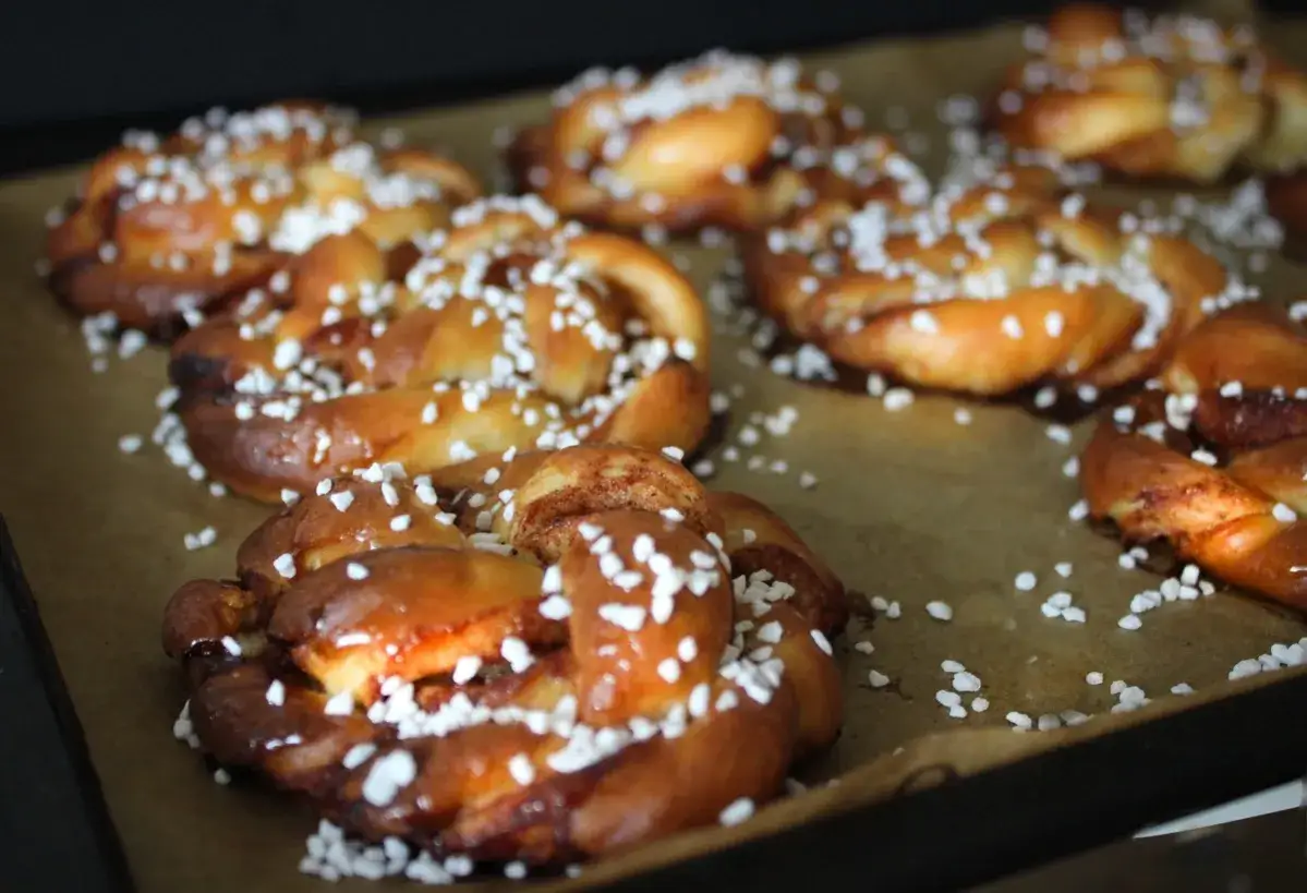 Nybakade kanelbullar med p&auml;rlsocker, redo att avnjutas. Ett klassiskt bullar recept som doftar ljuvligt.