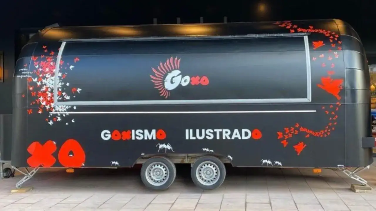 Food truck GoXO de Dabiz Muñoz, decorado con mariposas rojas y blancas, cerdos voladores y el lema