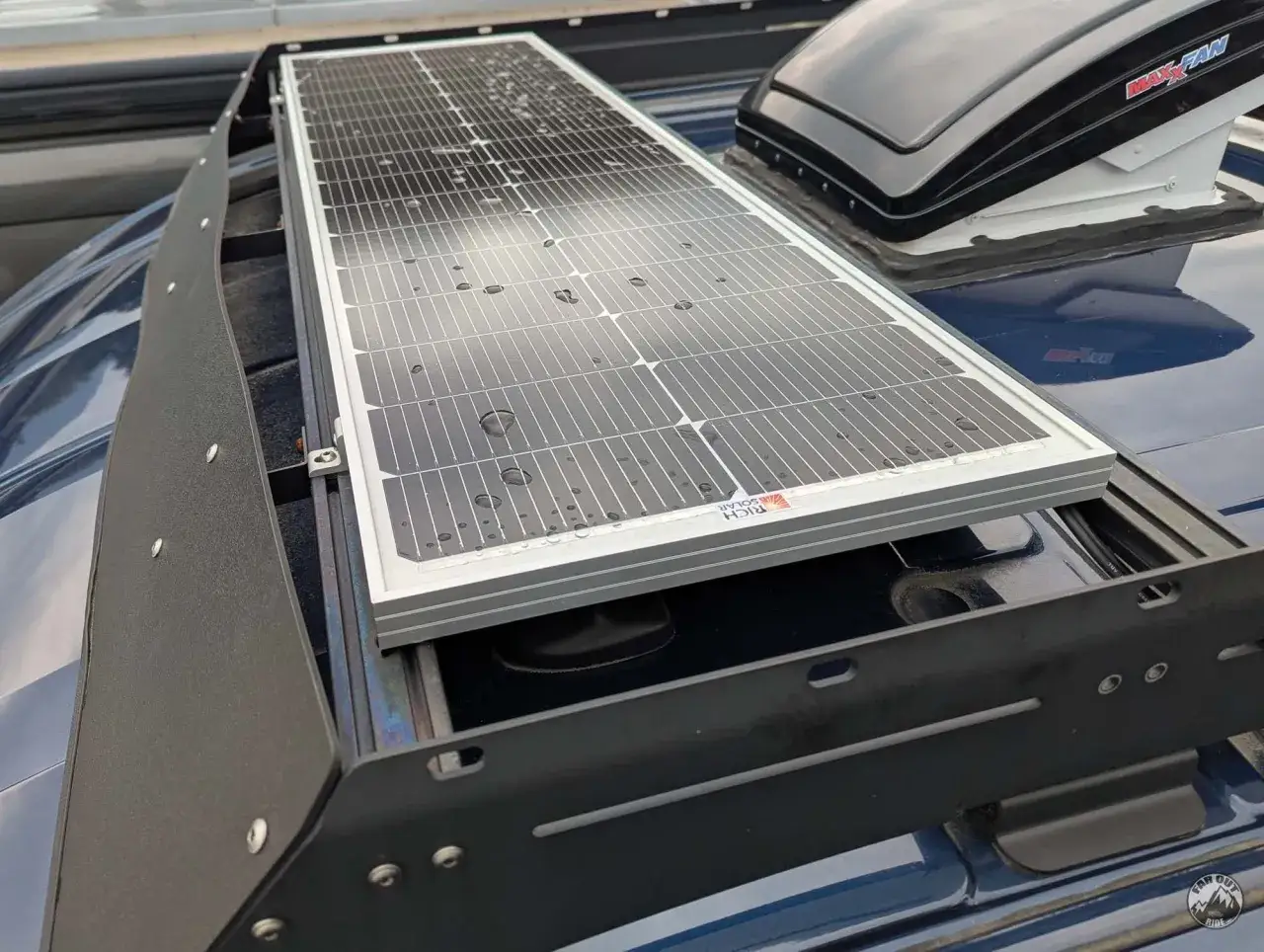 Panneau solaire installé sur une barre de toit, prêt à capter l'énergie du soleil pour une aventure en van.