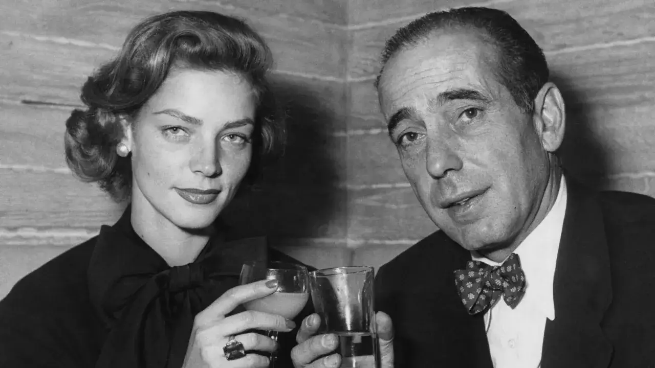 Lauren Bacall, żona Humphrey Bogarta, wznosi toast.