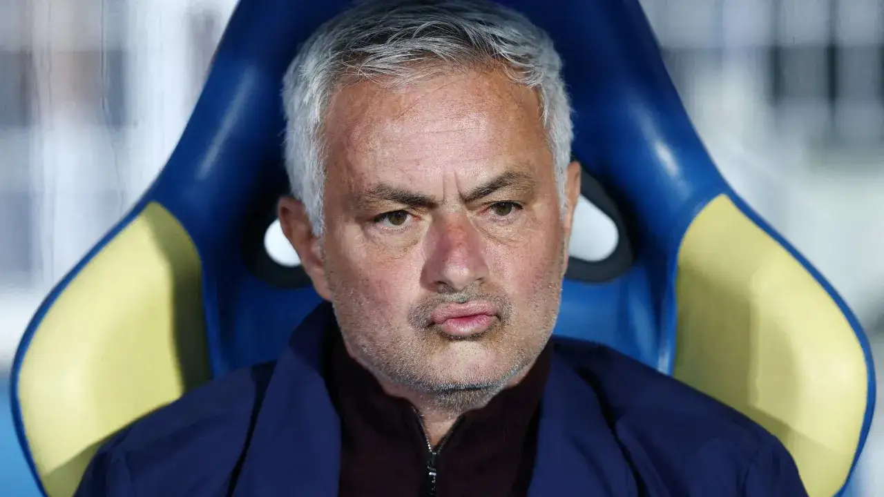 Jose Mourinho, były trener Realu Madryt, siedzi na ławce rezerwowych, zamyślony.