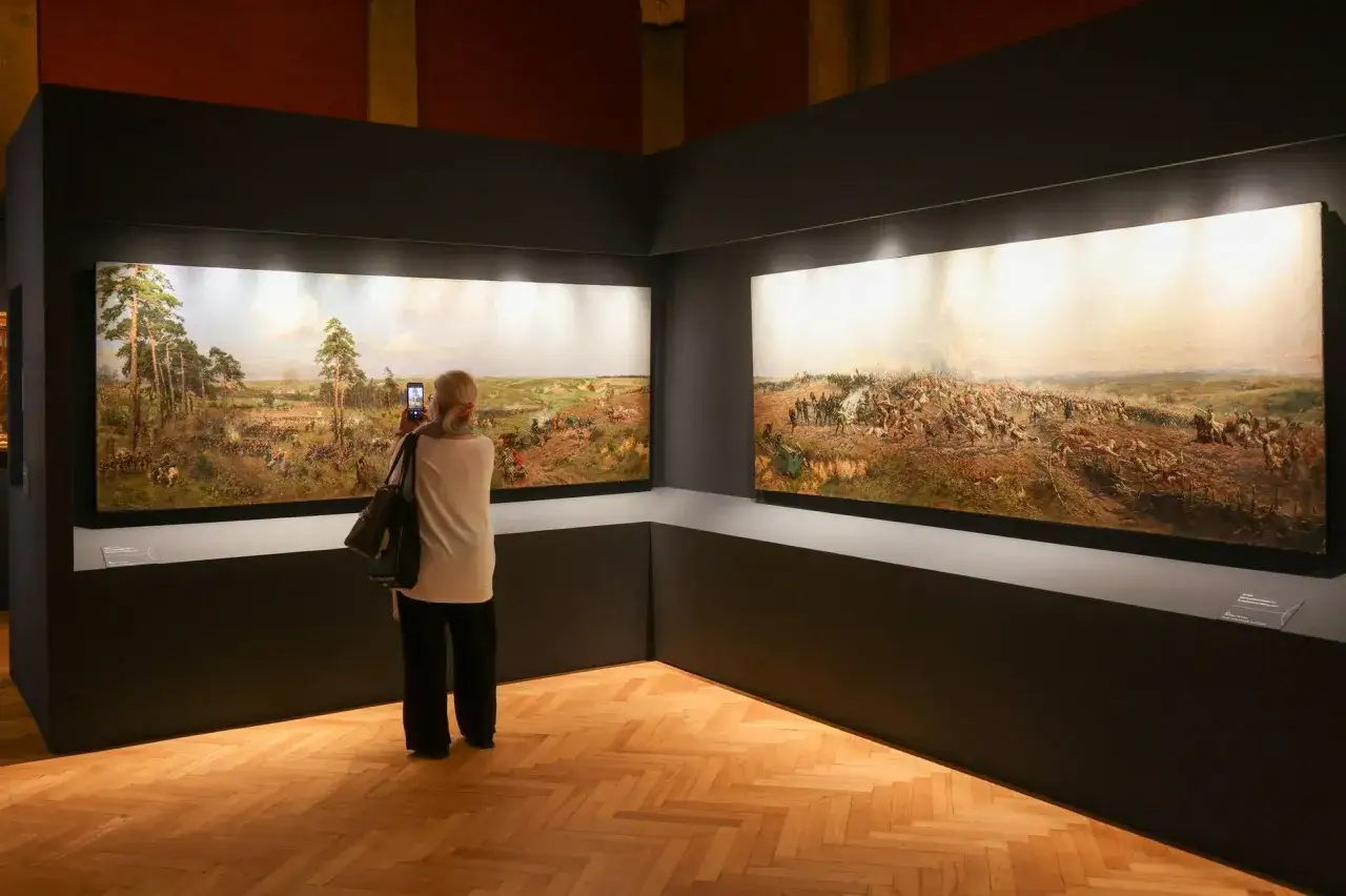 Kobieta fotografuje telefonem wielkie obrazy batalistyczne w jednym z muzeów Wrocławia.