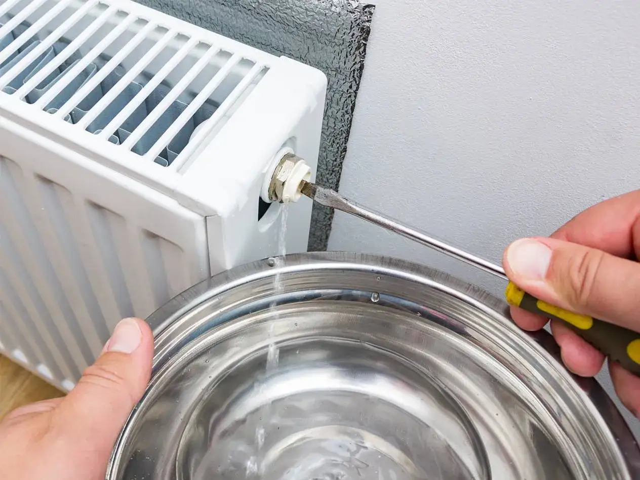 Lufta elementet f&ouml;r att f&aring; bort luftbubblor. Vatten rinner ner i en sk&aring;l n&auml;r en skruvmejsel anv&auml;nds f&ouml;r att &ouml;ppna ventilen.