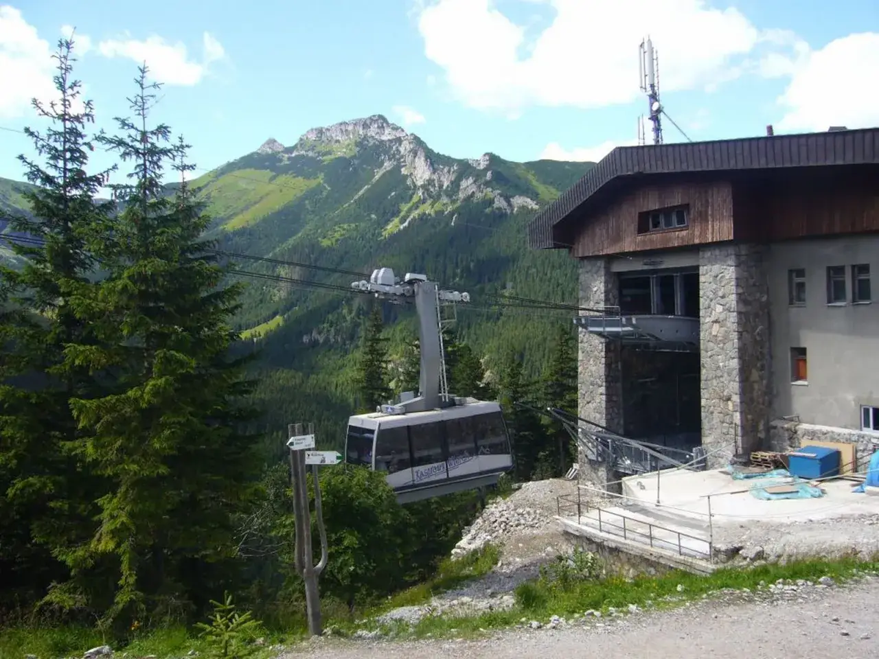 Kolejka linowa na Kasprowy Wierch zbliża się do stacji. W tle widać gęsto zalesione zbocza Tatr. Czy Giewont jest wyższy?