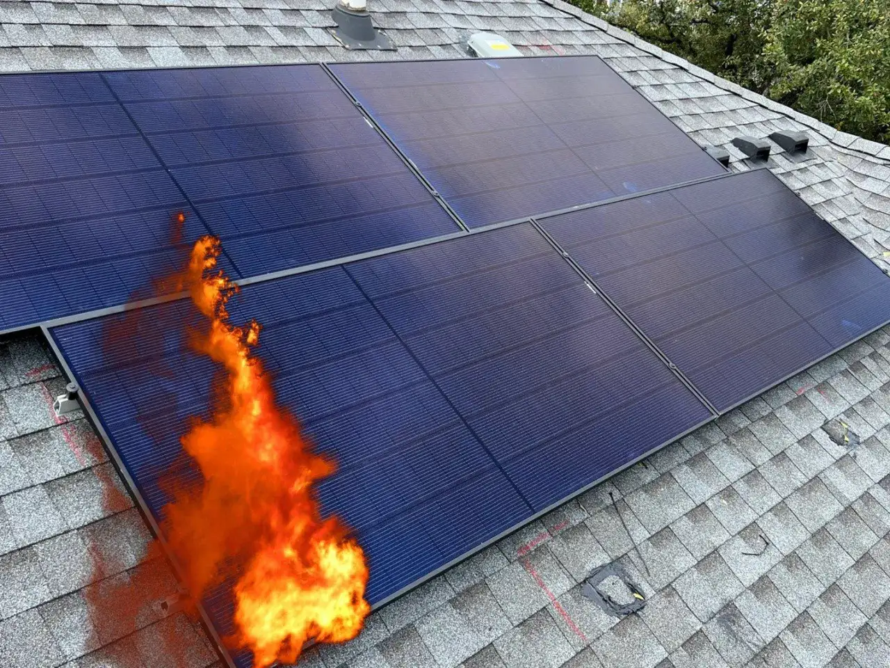 Solceller p&aring; ett tak brinner. En flammande brand sprider sig fr&aring;n en av panelerna, vilket visar en potentiell solceller brandrisk.