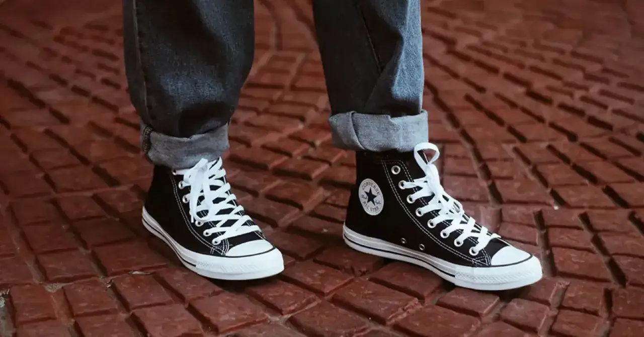 Schwarze Chucks mit wei&szlig;en Schn&uuml;rsenkeln auf rotem Pflaster. Zeit f&uuml;r die Chucks waschen!