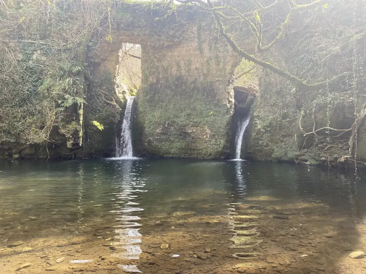 Cascate naturali a Barbarano Romano, con acqua cristallina che scende tra antiche rovine ricoperte di muschio.
