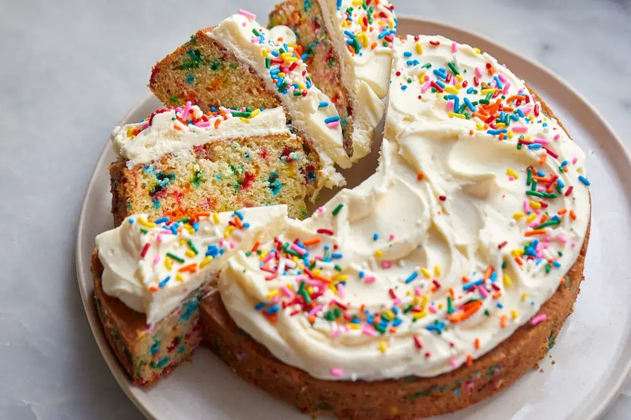 En härlig funfetti tårta med vit frosting och färgglada strössel. Perfekt för firande!