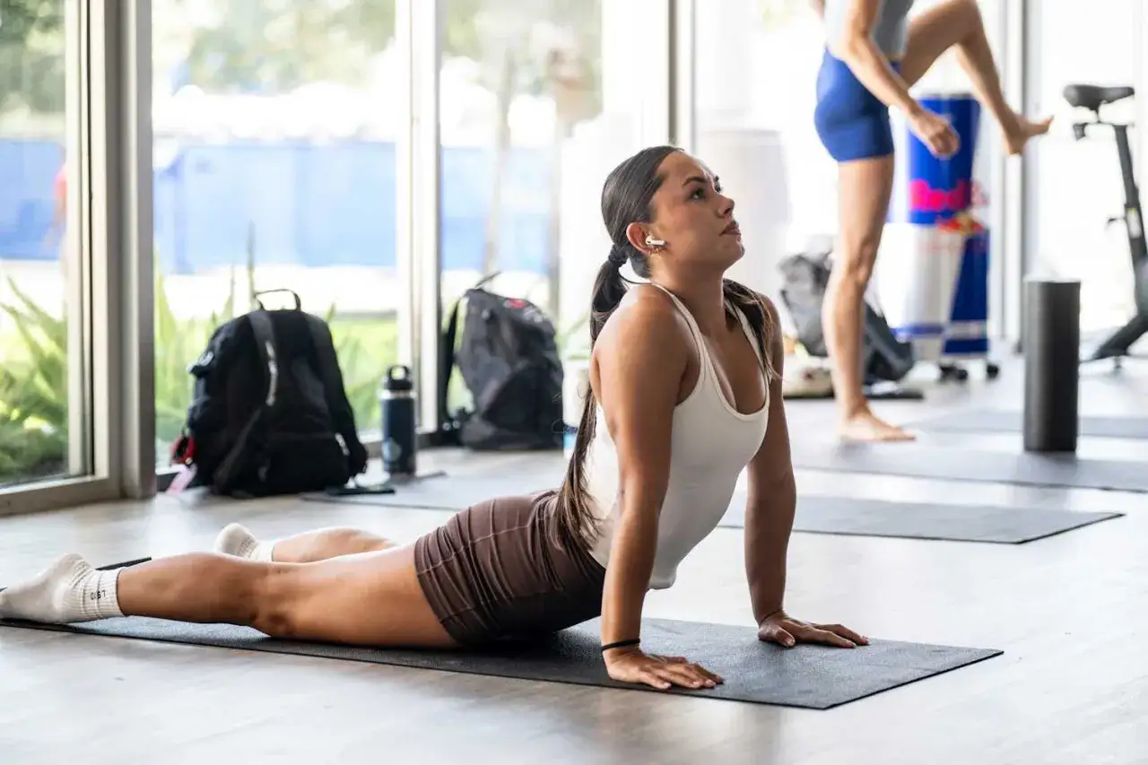 Femme en tenue de sport faisant des &eacute;tirements du dos sur un tapis de yoga, posture du cobra.