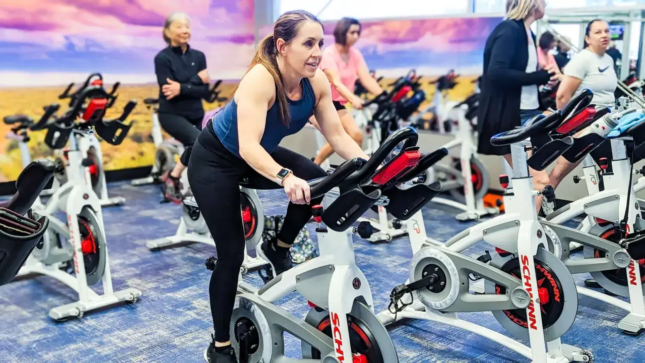 Frauen trainieren auf Spinningrädern. Ein intensives Cardio-Training, das auch den Muskelaufbau unterstützt.