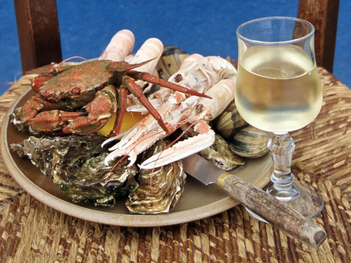 Meeresfrüchteplatte mit Krabben, Garnelen und Austern, dazu ein Glas erfrischender vinho verde.