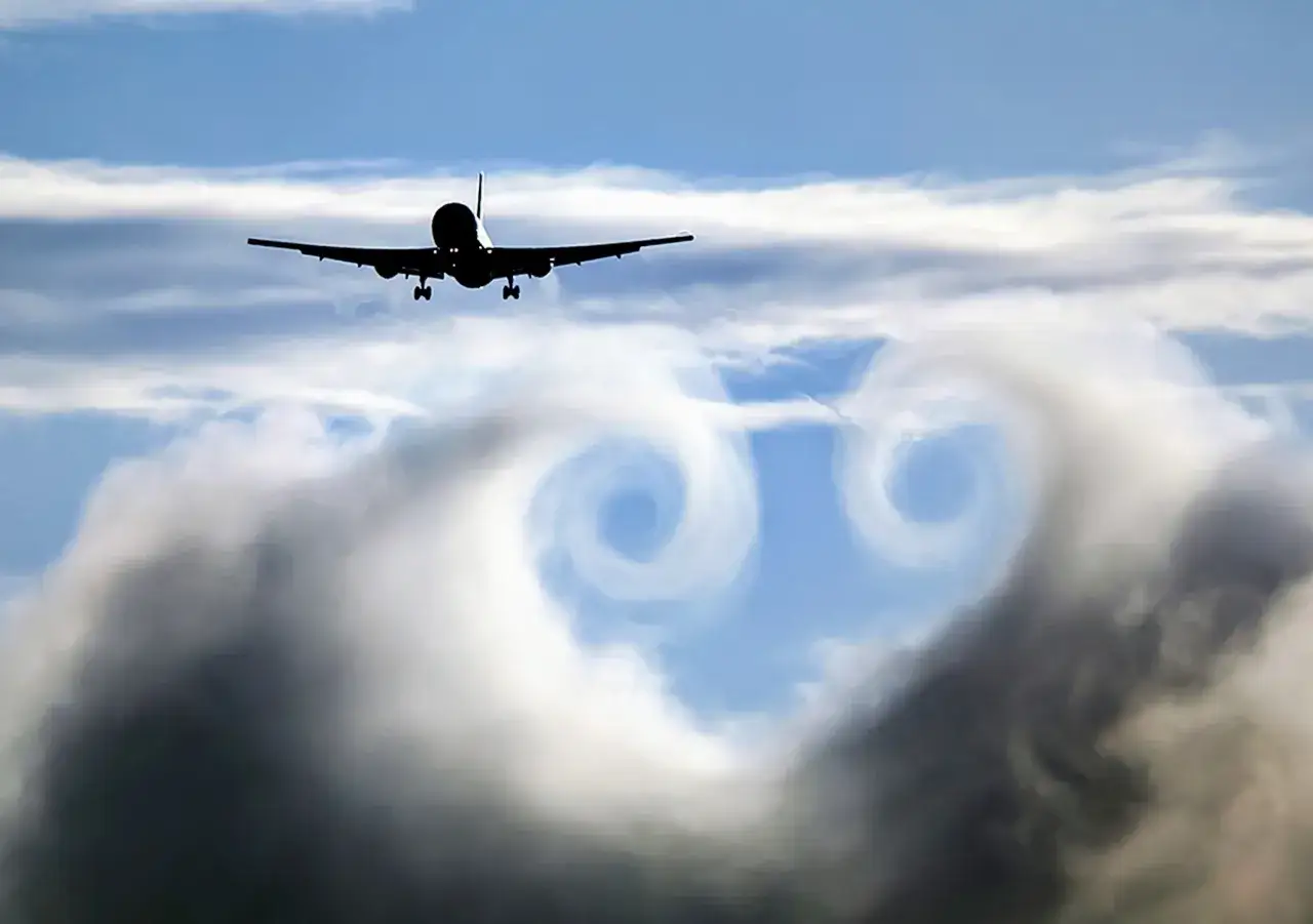 Ein Flugzeug fliegt durch den Himmel, hinterlässt Wirbel im Jetstream.