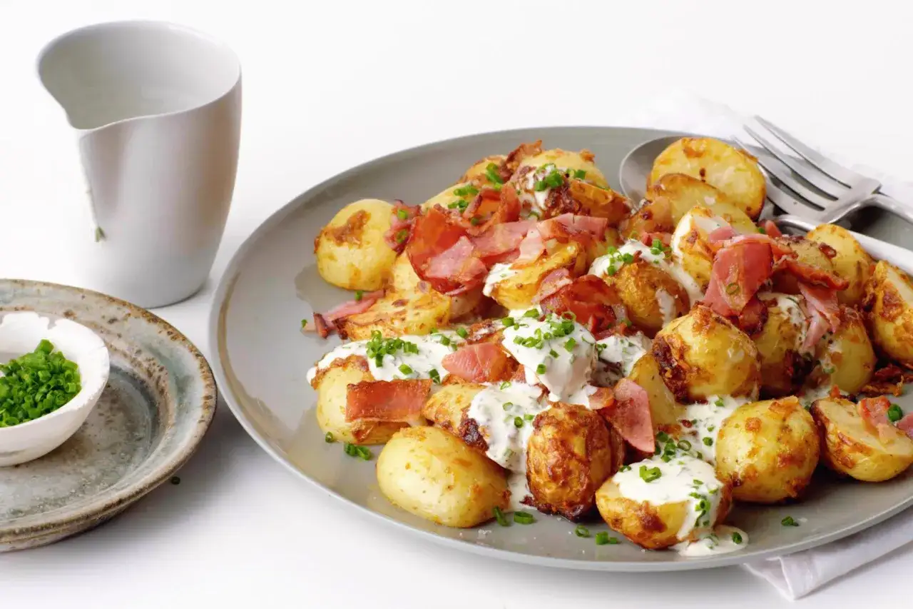 Krispiga potatis i airfryer med bacon och en krämig sås, toppad med gräslök. Enkel och god rätt.