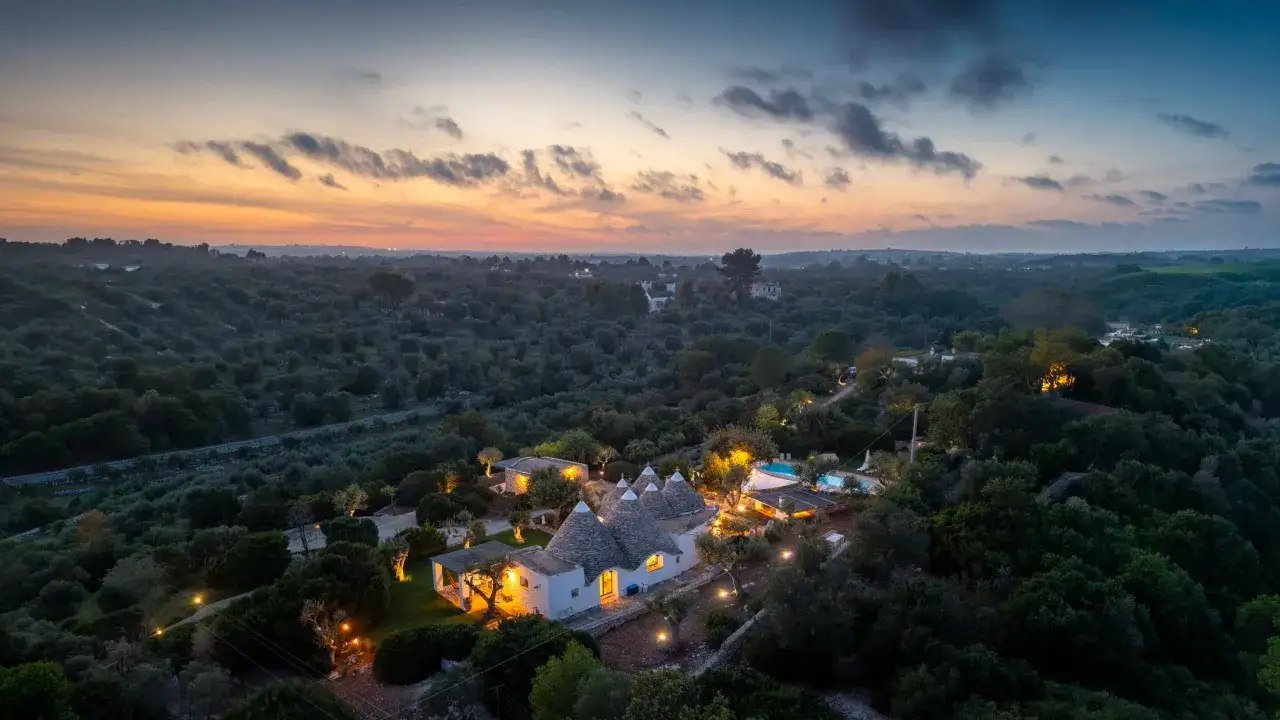 Trulli illuminati nella campagna pugliese al tramonto, un sogno per un tour Puglia 3 giorni.